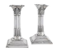 A MATCHED PAIR OF EDWARDIAN SILVER CORINTHIAN CANDLESTICKS