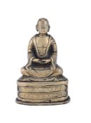 An unusual Tibetan small bronze seated figure of a Lama