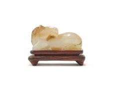 A Chinese small finely carved White Jade figure of a recumbent horse