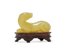 A Chinese yellow jade carving of a recumbent dog