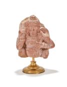 An Indian pink sandstone carving of Kubera
