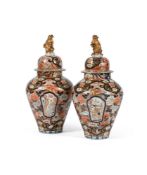 A large pair of Japanese Imari vases and covers