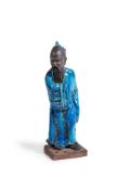 A CONTINENTAL GLAZED POTTERY MODEL OF AN IMMORTAL IN THE CHINESE STYLE, PROBABLY ITALIAN