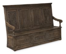 A CARVED OAK FOUR PANEL BOX SETTLE, LAST QUARTER 17TH CENTURY