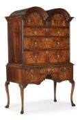 A GEORGE I WALNUT AND FEATHERBANDED DOUBLE-DOMED CHEST ON STAND, CIRCA 1715