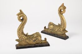 A PAIR OF VICTORIAN BRASS AND CAST IRON DOLPHIN DOOR STOPS OR DOOR PORTERS, MID 19TH CENTURY
