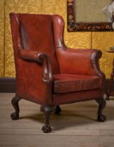A CARVED MAHOGANY AND RED LEATHER UPHOLSTERED WING ARMCHAIR, IN GEORGE II STYLE, 19TH CENTURY