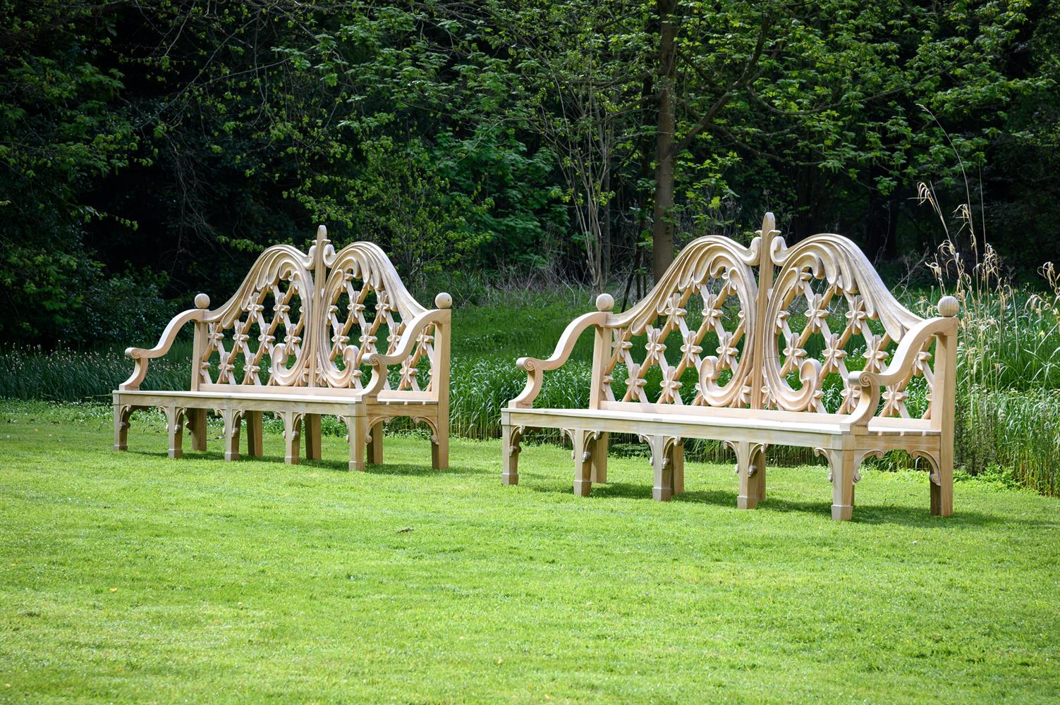 A LARGE PAIR OF CARVED TEAK LATTICE BACK GARDEN BENCHES, CONTEMPORARY