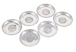 A SET OF SIX SILVER CIRCULAR DISHES
