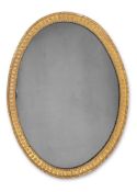 A GEORGE III CARVED GILTWOOD OVAL MIRROR, CIRCA 1810