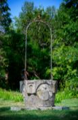 AN ITALIAN CARVED LIMESTONE AND WROUGHT IRON WELL HEAD, CIRCA 1910