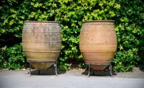 A PAIR OF TERRACOTTA AMPHORA WITH WROUGHT IRON STANDS, LATE 20TH CENTURY