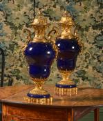 A PAIR OF FRENCH GILT METAL MOUNTED DEEP BLUE GLAZED PORCELAIN URNS AND COVERS, LATE 19TH CENTURY