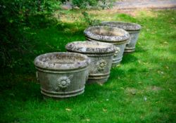A SET OF FOUR COMPOSITION STONE PLANTERS, 20TH CENTURY