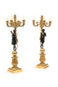 AFTER PIERRE-PHILIPPE THOMIRE, A PAIR OF EMPIRE GILT AND PATINATED BRONZE FIGURAL CANDELABRA