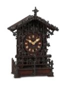 A RARE BLACK FOREST CARVED OAK QUARTER-STRIKING ‘CUCKOO AND QUAIL’ MANTEL CLOCK