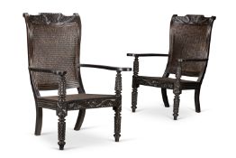 Y‡ A PAIR OF CEYLONESE EBONY AND CANED ARMCHAIRS, FIRST HALF 20TH CENTURY