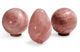 TWO POLISHED ROSE QUARTZ SPHERES AND A POLISHED ROSE QUARTZ EGG