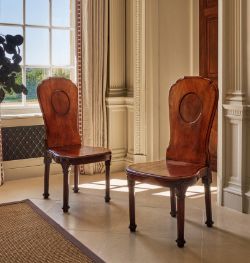 A FINE PAIR OF GEORGE III MAHOGANY HALL CHAIRS, IN THE MANNER OF THOMAS CHIPPENDALE, CIRCA 1760