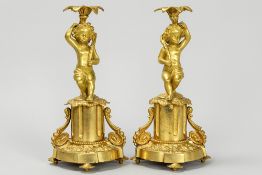 pair of antique neoclassical candlesticks in gilded bronze, each with a Cupid