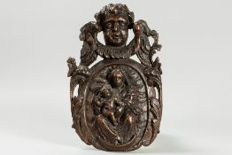 18th Cent. sculpture in oak with a medallion with "Mary and child" topped by a cupid