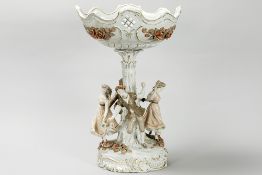 quite big centerpiece with a bowl resting on a tree trunk surrounded by four figures