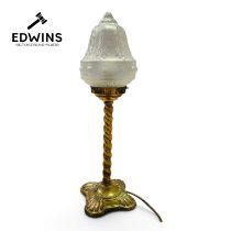 A 20th Century table lamp with a twisted brass base and a frosted glass shade.