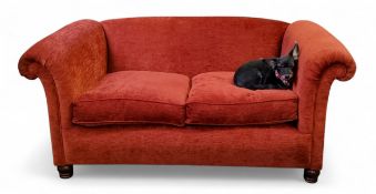 A 20th century roll arm two-seat sofa, upholstered in burnt red textured chenille,  turned