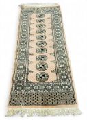 An Afghan Bokhara woollen runner, in shades of pink, peach, black and cream, 162cm x 66cm