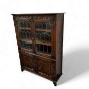 A Jaycee furniture oak side cabinet, carved lunette frieze, above a  pair of astragal glazed doors