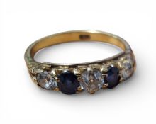 An 18ct gold, diamond and sapphire ring, claw set with a central approx. 0.25ct round diamond,