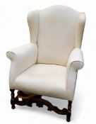 A late 19th/early 20th century wingback armchair, in the William and Mary style,  the arched back