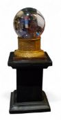 Mysticism and the Occult - a crystal ball, on ebonisedand gilt empire stand, 16cm high overall