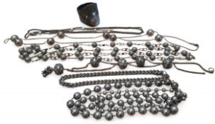 A white metal Middle Eastern ball and wire work necklace; three others; a white metal fancy curb