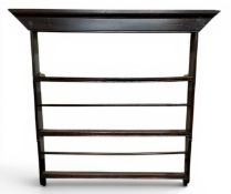 A George III oak wall mounted three tier plate rack, moulded cornice,  106cm high, 103cm wide, c.