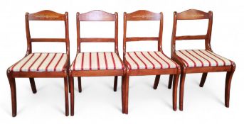 A set of four stained mahogany dining chairs, in the Regency style, sabre legs