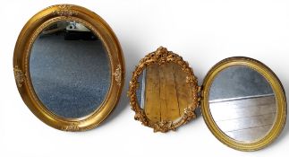 A 20th century gilt oval mirror, 86cm x 66cm;   another, smaller, 60cm x 50cm;   a gilt rococo