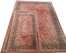 A Super Taj  rug, with central medallion and foliate scrolls, on a red ground, banded border,
