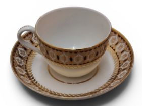A Pinxton Bute teacup and saucer, pattern No. 281, decorated with dark red-brown and gilt border
