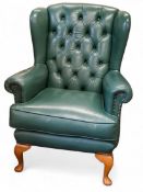An early 20th century green faux leather wing back chair, button back, cabriole legs, pad feet, c.