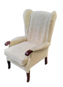 A 20th century wing back side chair,  cream with  white scrolls, 111cm high, 71cm wide