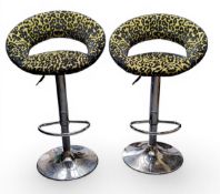 A pair of chrome and leopard print bar stools, 88cm high