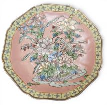 A Chinese shaped circular plate, with relief with peonies and other foliage, on a pink ground,