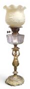 A Victorian gilt metal figural oil lamp, tulip shaped relief moulded shade, clear glass facetted