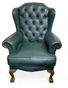 An early 20th century green faux  leather wing back chair, button back, cabriole legs, ball and claw