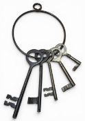 A set of five graduated brass keys on a large key ring, the largest key 17cms long