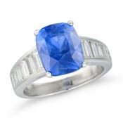 A CEYLON SAPPHIRE AND DIAMOND RING set with a cushion cut sapphire of 5.27 carats, the band set with