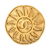 CHANEL, A CC SUNBURST BROOCH comprising a circular gold tone brooch with an interlocking CC logo in