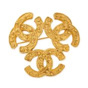 CHANEL, A TRIPLE CC LOGO BROOCH comprising a gold tone brooch with three textured interlocking CC lo