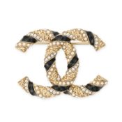 CHANEL, A CC LOGO BROOCH comprising an interlocking CC in gold tone metal decorated with black